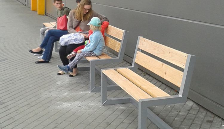 Lidé si na zastávce městské hromadné dopravy u Mercury mohou při čekání na spoj už sednout