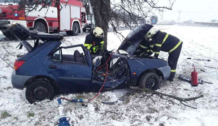 Řidička se svým autem narazila do stromu. Vyprostit ji museli přivolaní hasiči