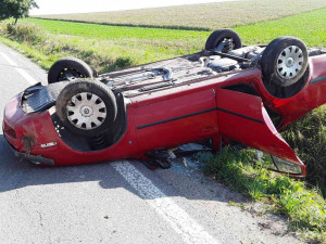 Výsledkem nehody náklaďáku s osobákem je zraněná řidička. Její auto skončilo na střeše