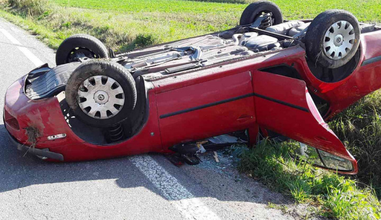 Výsledkem nehody náklaďáku s osobákem je zraněná řidička. Její auto skončilo na střeše