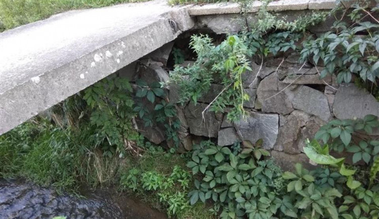 Betonová lávka přes Koželužský potok je v havarijním stavu. Momentálně je neprůchozí