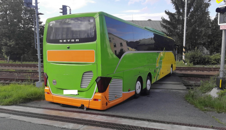 Řidič autobusu se chtěl vyhnout komplikacím na dálnici, tak z ní sjel. Uvízl ale na přejezdu