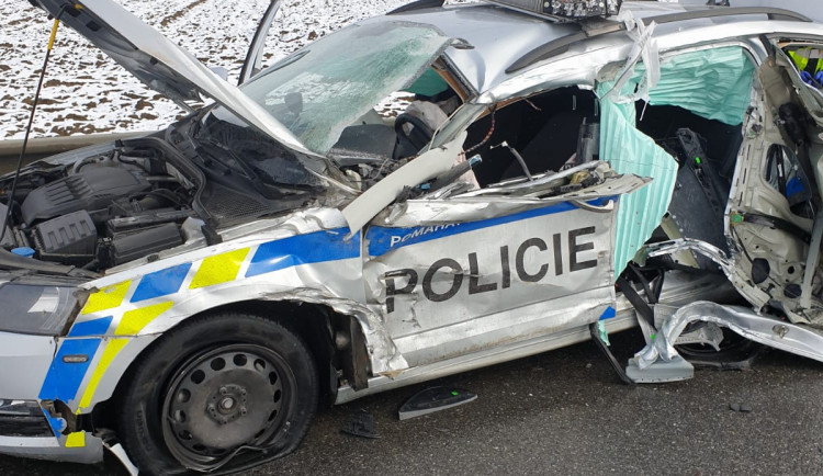 Tři zranění po nehodě nákladního auta s policejním vozem. Silnice 23 je neprůjezdná