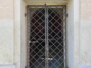 Pryč s vlhkostí. Kaplička v Kosově má nyní místo dveří kovanou mříž