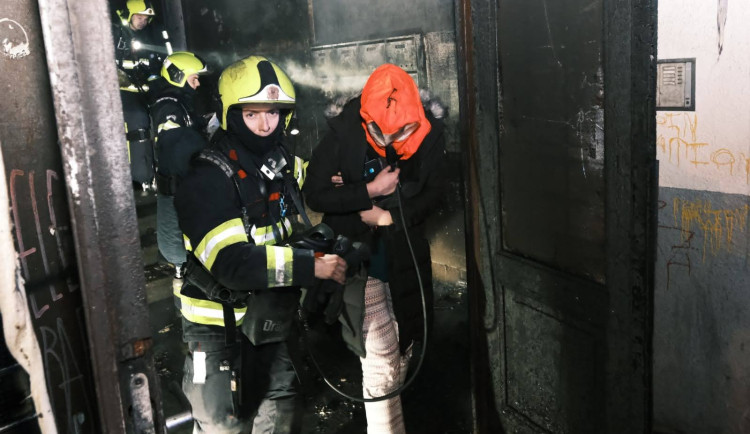 V Trojické ulici hořelo v chodbě domu. Hasiči zachraňovali deset lidí