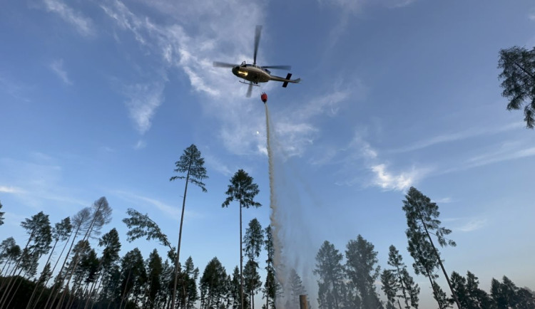 Deset jednotek hasičů vyjelo k požáru lesa. Do hašení se shazováním vody zapojil i vrtulník