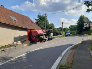 Mladý traktorista nezvládl průjezd zatáčkou, na dům a silnici vysypal 16 tun pšenice