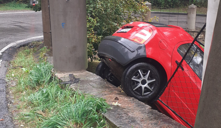 Řidič za volantem Škody Fabie prorazil oplocení u zámeckého parku a zůstal viset nad srázem. Foto: se souhlasem Policie ČR