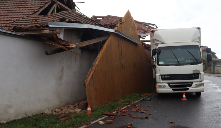 Řidič nákladního vozu se v zatáčce vyhýbal autobusu, strhl střechu domu. Foto: Policie ČR