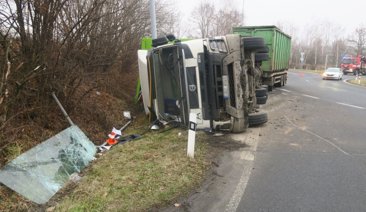 Převrácený kamion s odpadem blokoval kruhový objezd u Hranic. Řidič zůstal zaklíněný v kabině