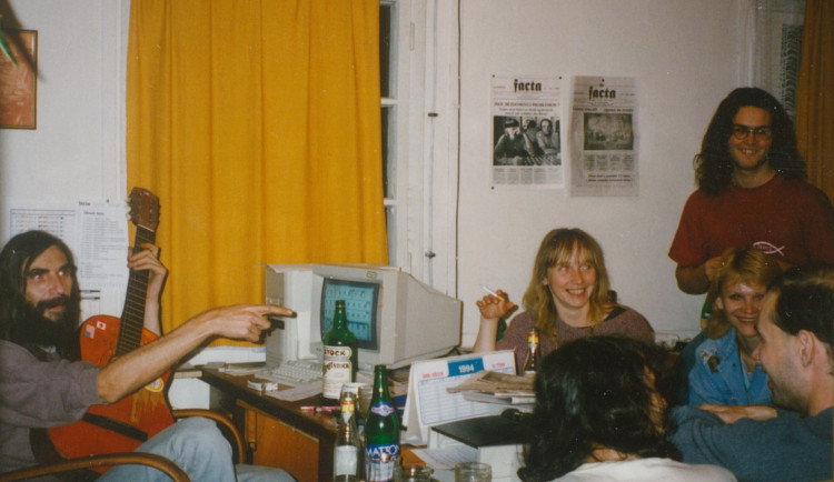 Na snímku s kytarou Leo Švančara, Jana Pechová, Jan Řezáč a další členové redakce novin Facta v tehdejším newsroomu v dřevěném srubu ve Srázné ulici.