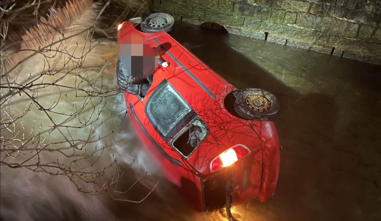 Kuriozní nehoda v Liberci. Řidič sjel v noci autem do Nisy, na hasiče čekal usazený na okénku