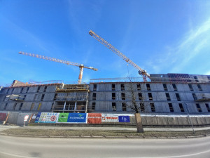 FOTO: Dělníci staví poslední patro vysokoškolských kolejí, soudní spory pokračují