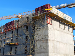 FOTO: Dělníci staví poslední patro vysokoškolských kolejí, soudní spory pokračují