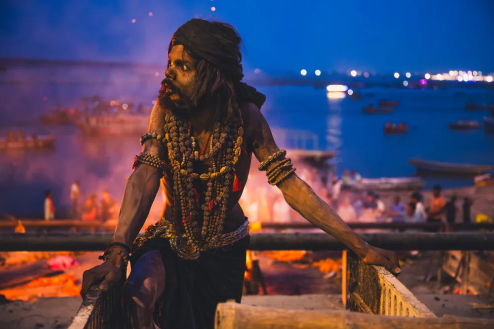 Aghori a za ním hořící kremační oheň ve Varansí