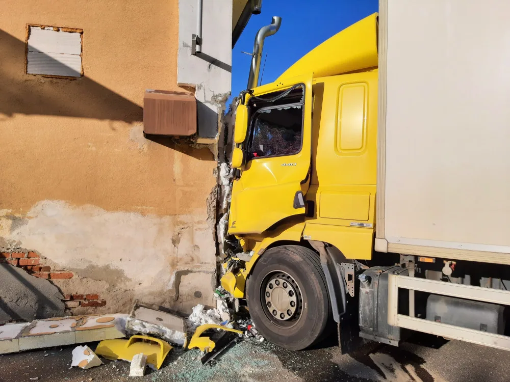 Nepozornost za volantem. Řidička v náklaďáku vyjela mimo silnici a narazila do budovy