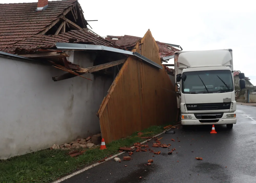 Řidič nákladního vozu se v zatáčce vyhýbal autobusu, strhl střechu domu. Foto: Policie ČR