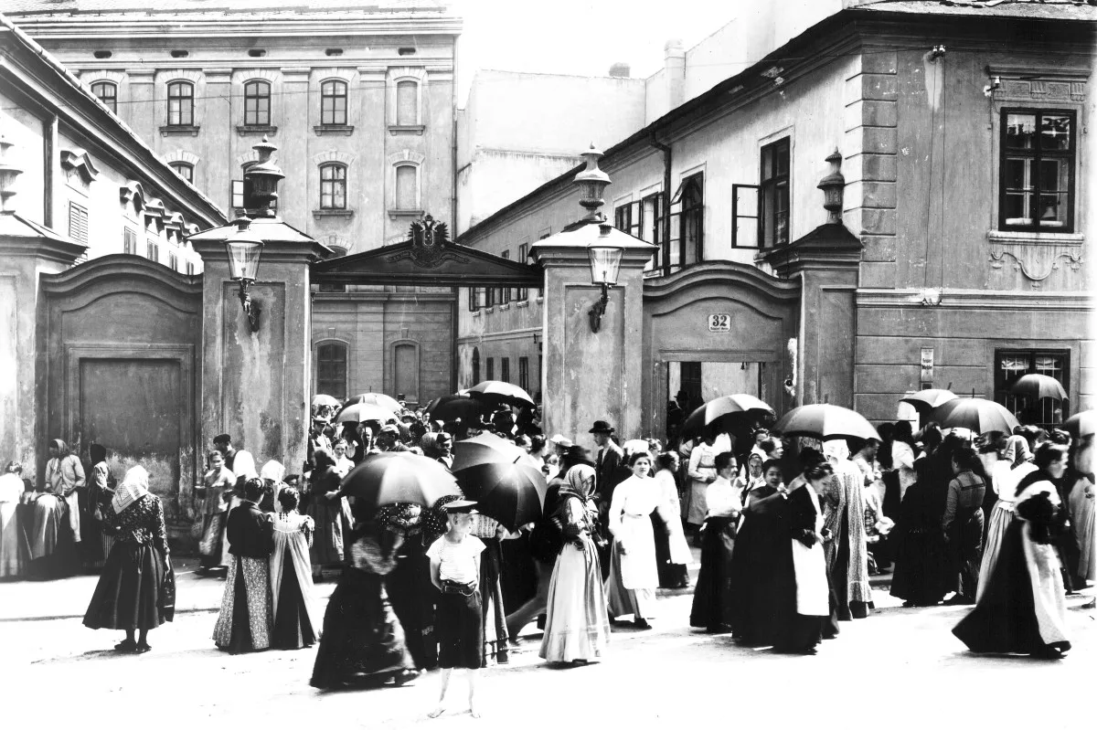 Ženy odcházejí domů. Konec pracovní směny v jihlavské tabákové továrně v Havlíčkově ulici. Snímek před rokem 1918