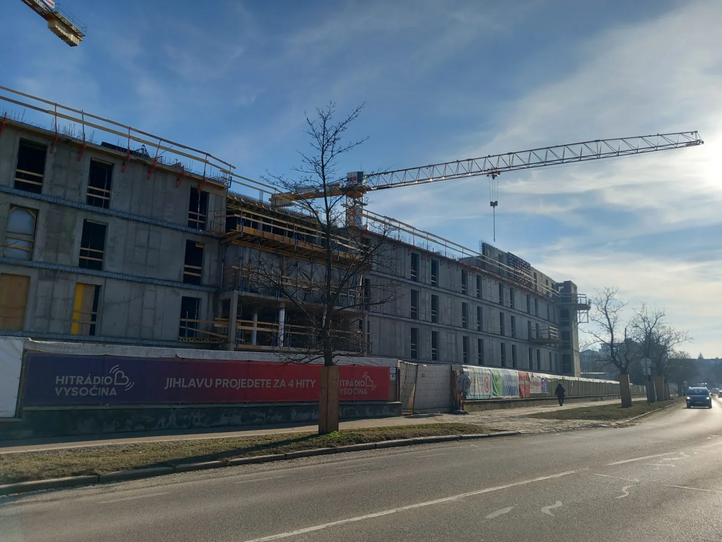 FOTO: Dělníci staví poslední patro vysokoškolských kolejí, soudní spory pokračují