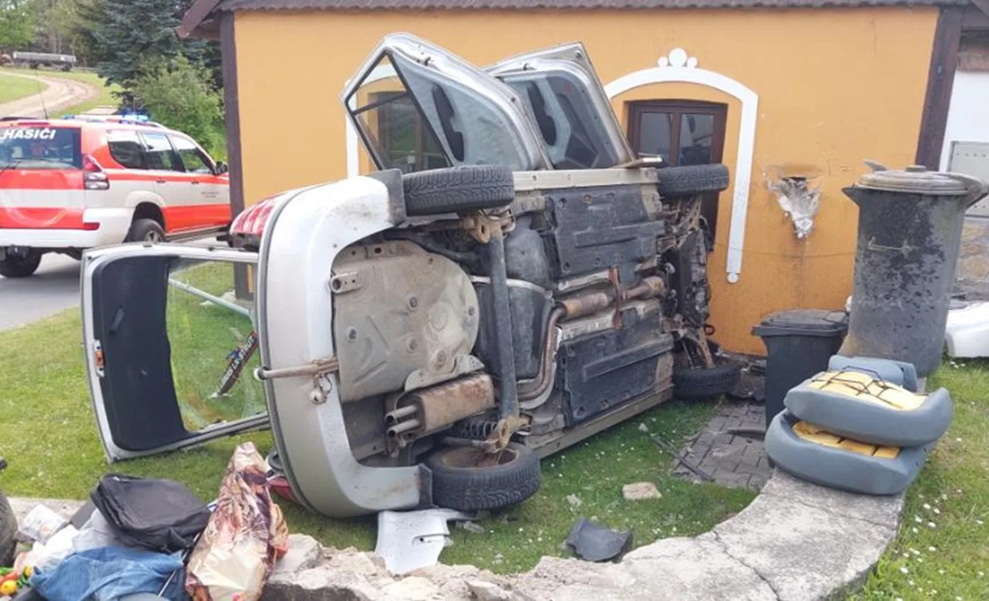 Senior v Kameničce jel po chodníku, potom narazil do domu a otočil auto na bok. Foto: Policie ČR