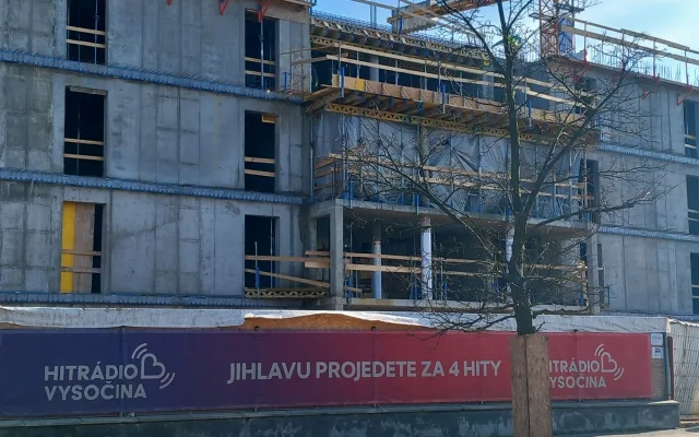FOTO: Dělníci staví poslední patro vysokoškolských kolejí, soudní spory pokračují