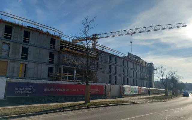 FOTO: Dělníci staví poslední patro vysokoškolských kolejí, soudní spory pokračují