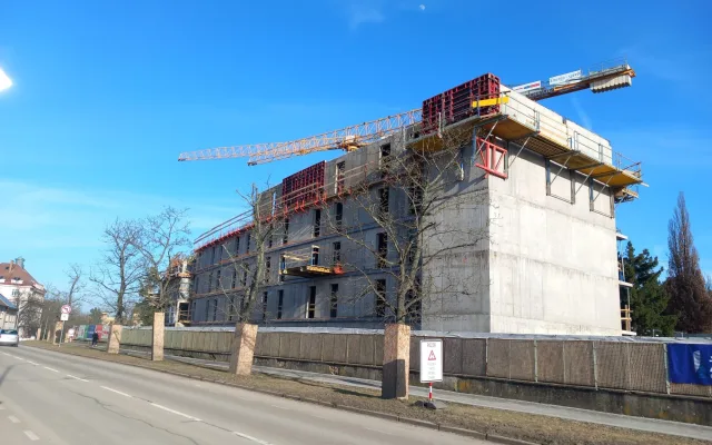 FOTO: Dělníci staví poslední patro vysokoškolských kolejí, soudní spory pokračují