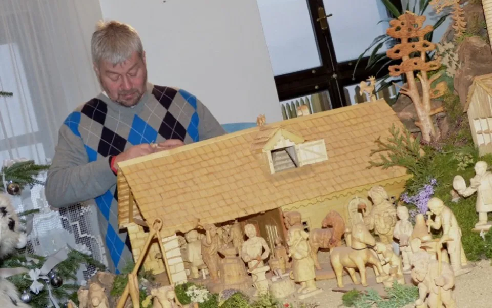 Řezbář Evžen Hamták při vyřezávání jedné z postav v Schumpeterově domě  