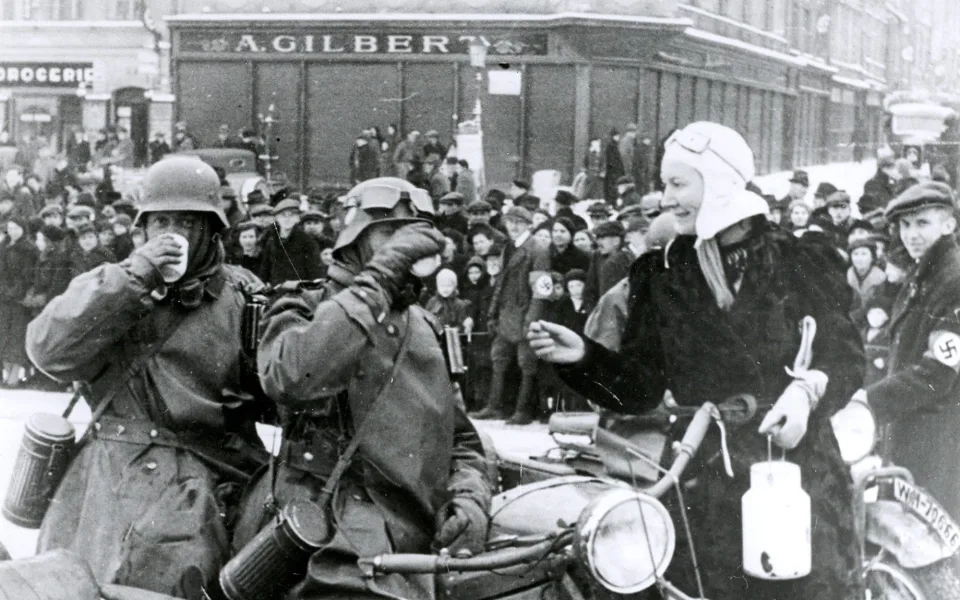 Jihlavské náměstí dopoledne 15. března 1939. Žena přinesla německým vojákům něco pro zahřátí.